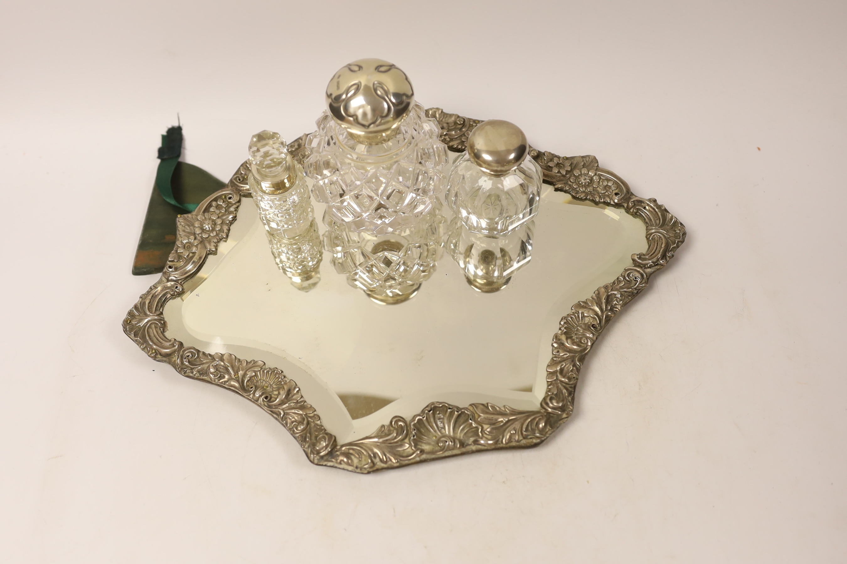 An Edwardian silver mounted easel mirror, Sheffield, 1902 (a.f.), together with three assorted silver mounted glass scent bottles.